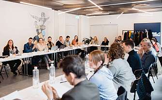 Teilnehmer einer Besprechung in einem hellen, modernen Raum.