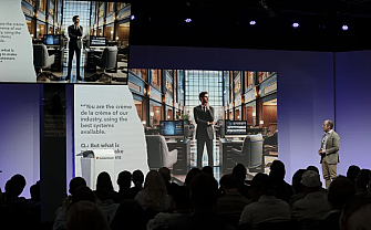 A speaker stands in front of a large screen presentation.