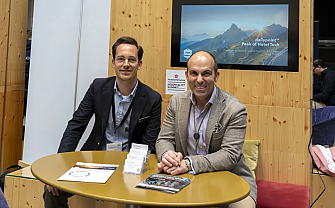 Two men sitting at a table at an event.